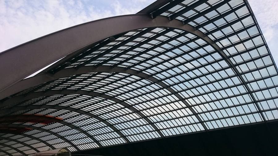 A curved black steel frame roof seen from below